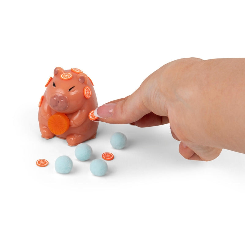 Orange Scrunchems Sticky Squishy Capybara toy with small citrus decorations and blue soft sensory pieces